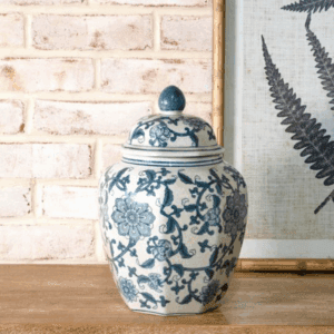 Blue and white ceramic jar with floral patterns on a wooden surface.